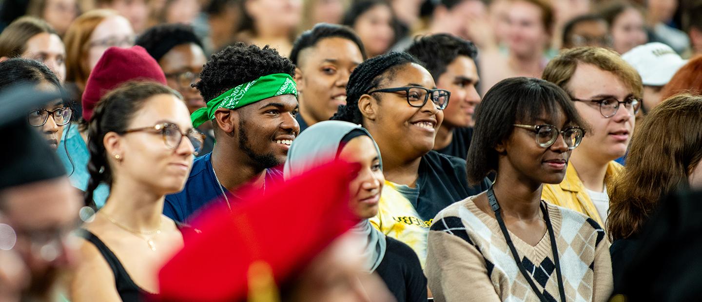 A crowd of young people stands together smiling